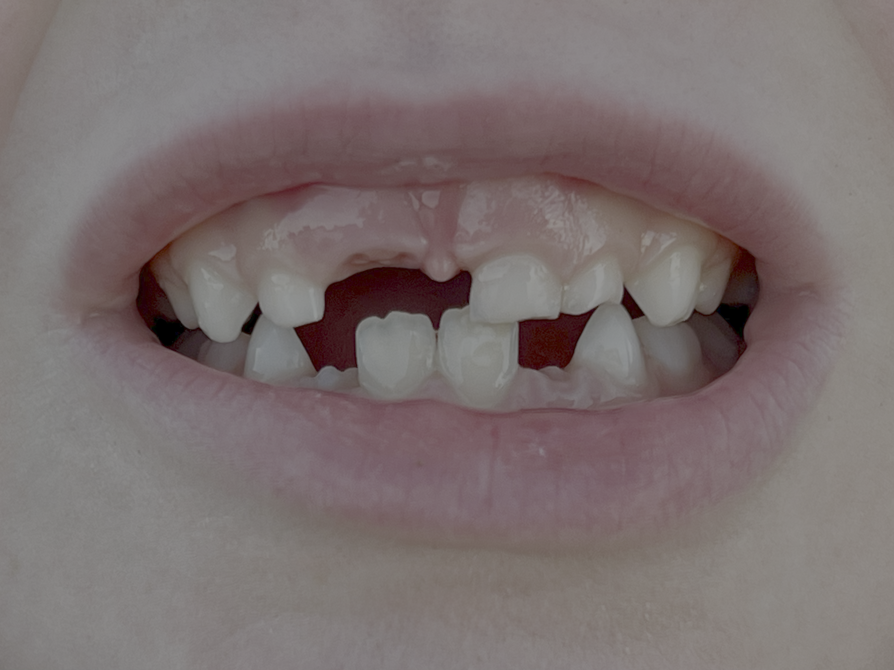 Faglegt teymi tannlæknastofunnar í hvítum köppum brosandi í nútímalegri stofu